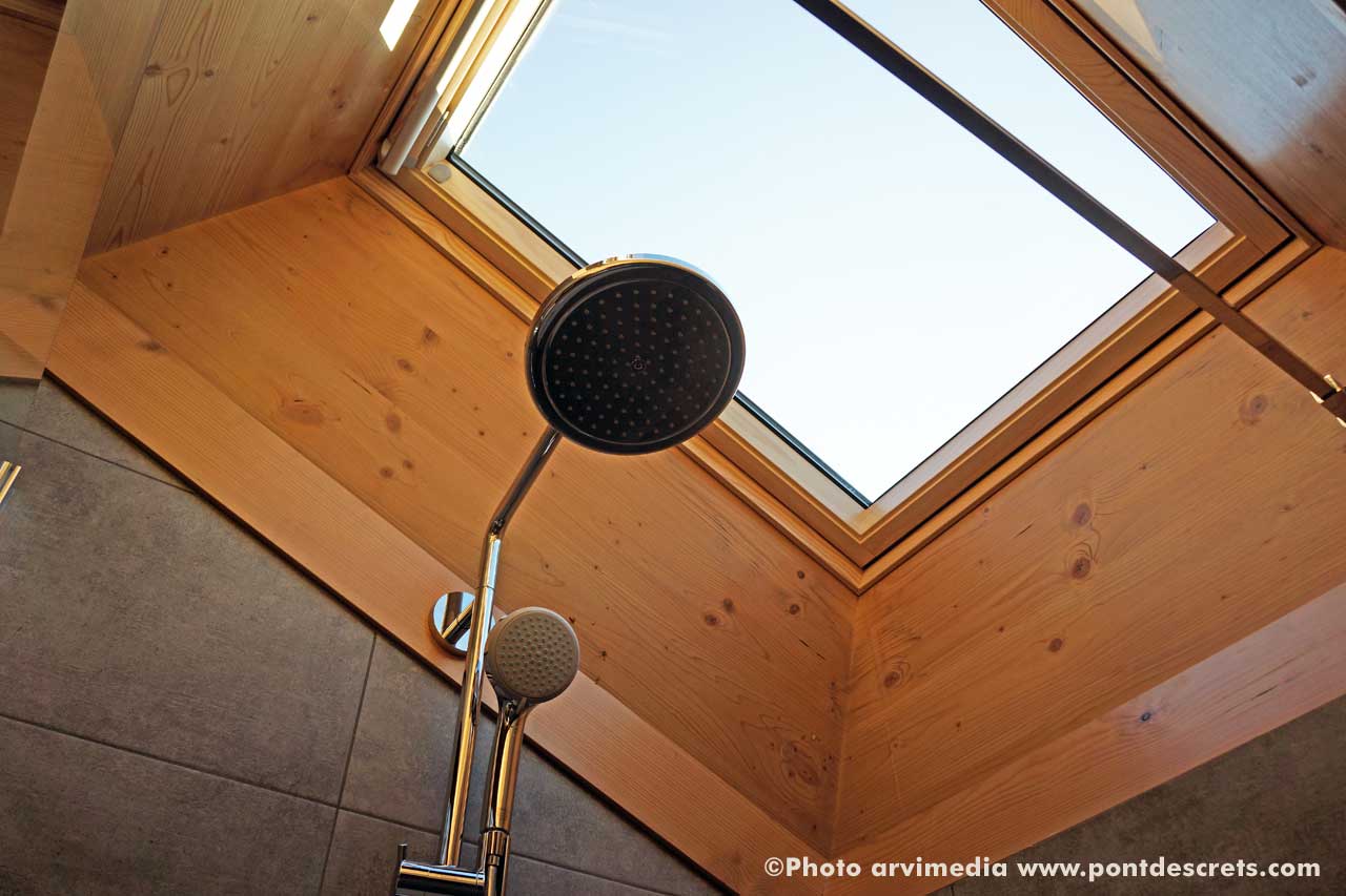 la salle de bain est innondée de lumière grâce à un grand velux photo arvimedia pour le pont des crêts à la clusaz
